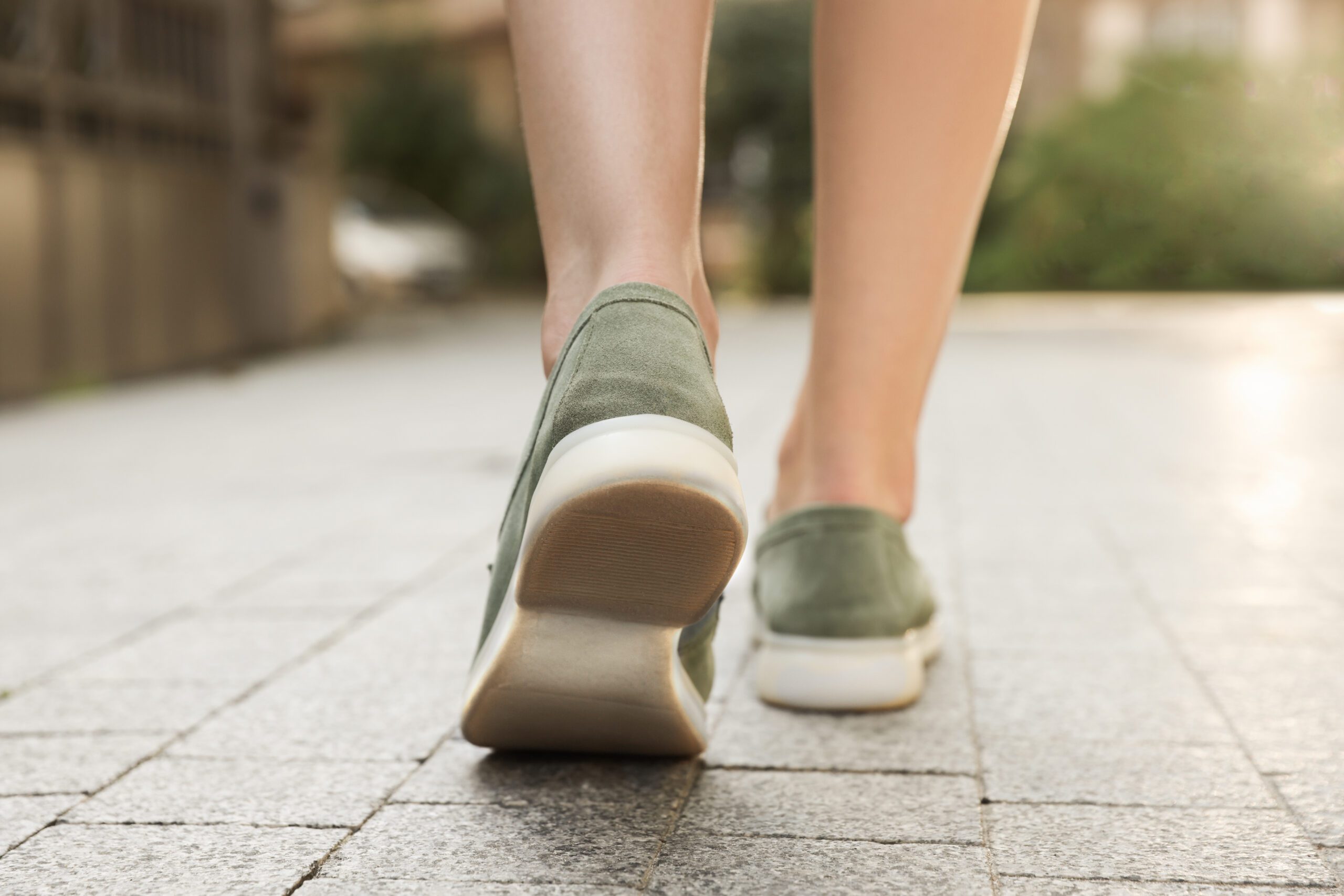 Woman in stylish loafers walking on city street, closeup